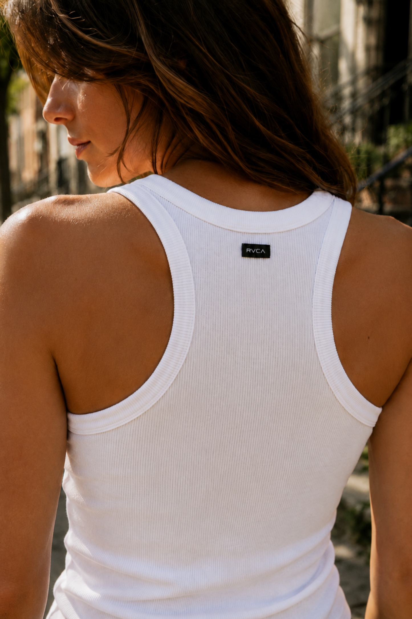 Camisole de sport blanche côtelée vue de dos avec dos nageur et petite étiquette au col.