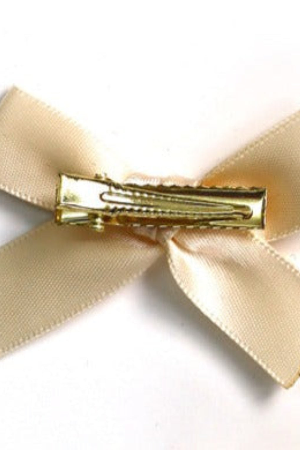 Vue arrière d’une barrette dorée fixée à un ruban en satin vert sauge, mini boucle élégante.