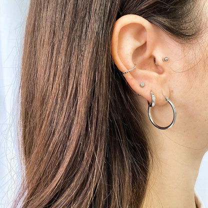 Ear cuff torsadé argent porté sur oreille - Style moderne et discret