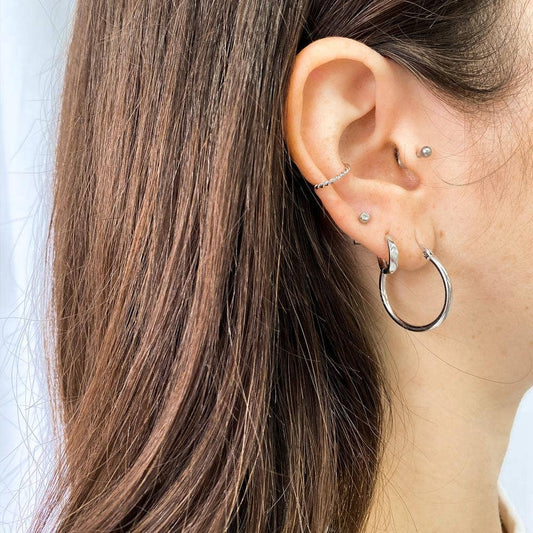 Ear cuff torsadé argent porté sur oreille - Style moderne et discret