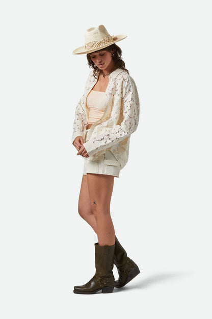 Chemise crème portée ouverte – look complet avec short clair et chapeau