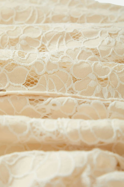 Gros plan sur la matière en dentelle crème – détails de la broderie florale
