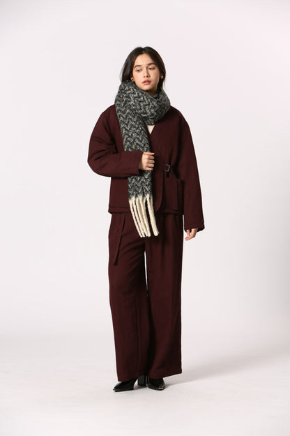 Écharpe noire à motif chevron avec franges blanches, portée sur ensemble bordeaux