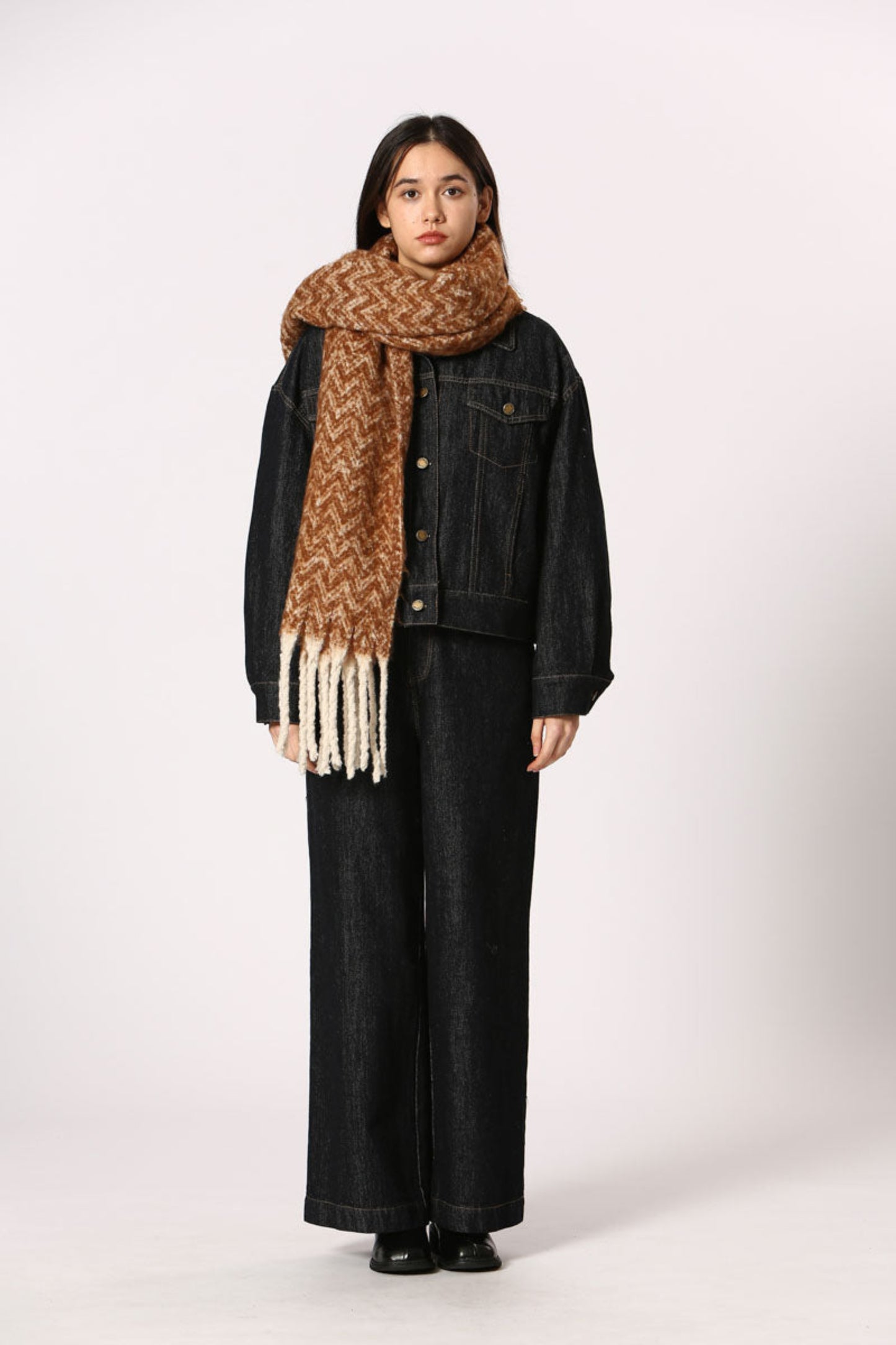 Écharpe terracotta à motif chevron avec franges blanches, portée avec veste en denim
