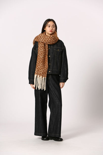 Écharpe terracotta à motif chevron avec franges blanches, portée avec veste en denim