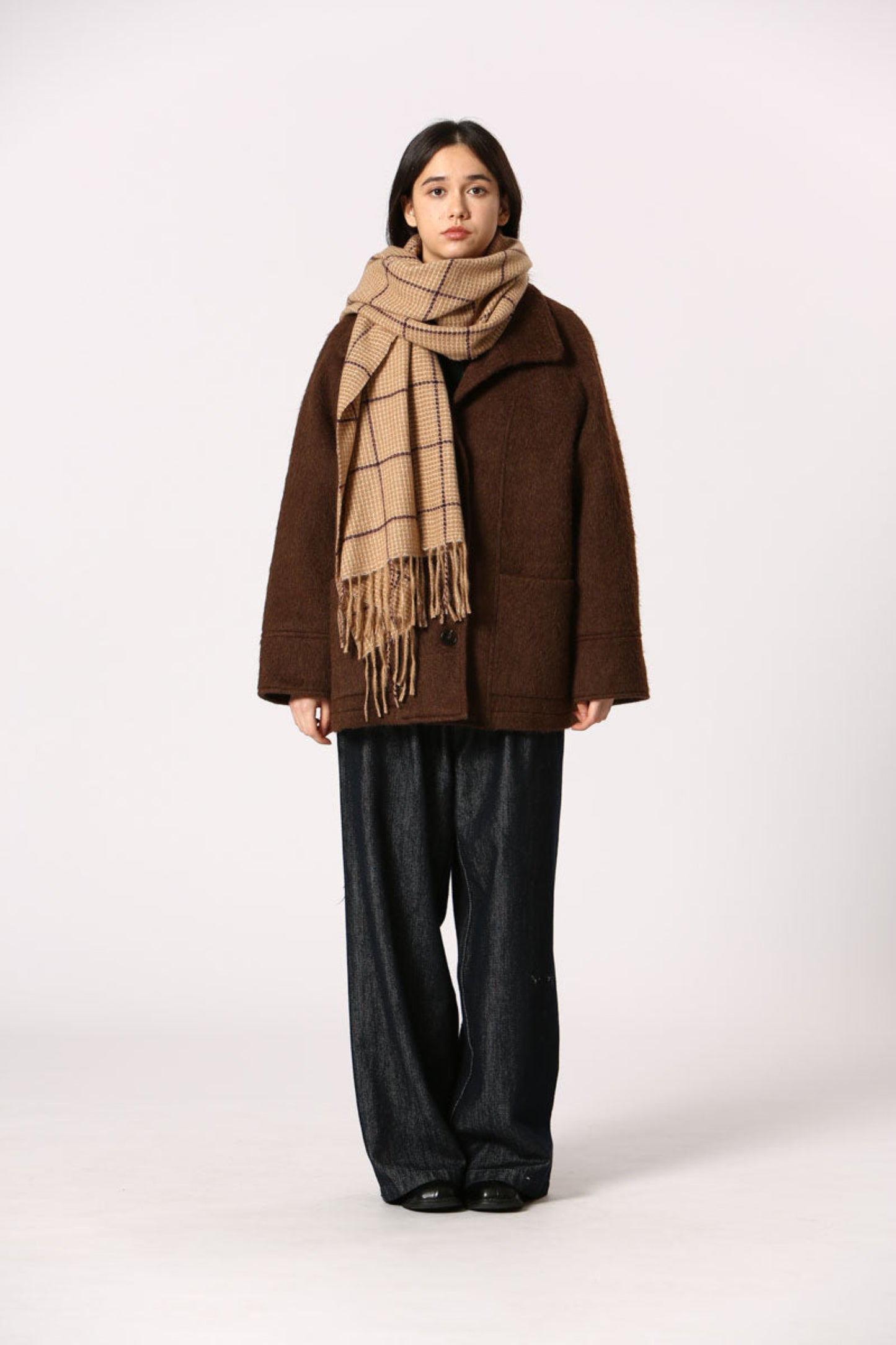 Femme portant l’écharpe Kate beige autour du cou + motif carreaux