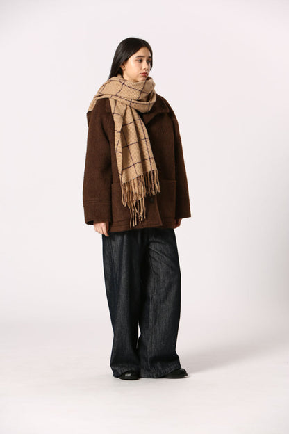 Femme portant l’écharpe Kate beige sur un manteau brun + look hiver