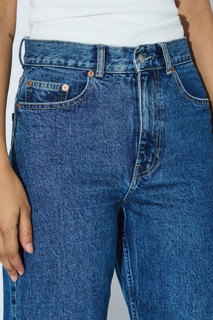 Détail de la taille du jeans Echo bleu denim rétro avec bouton, passants, poches classiques et braguette zippée.