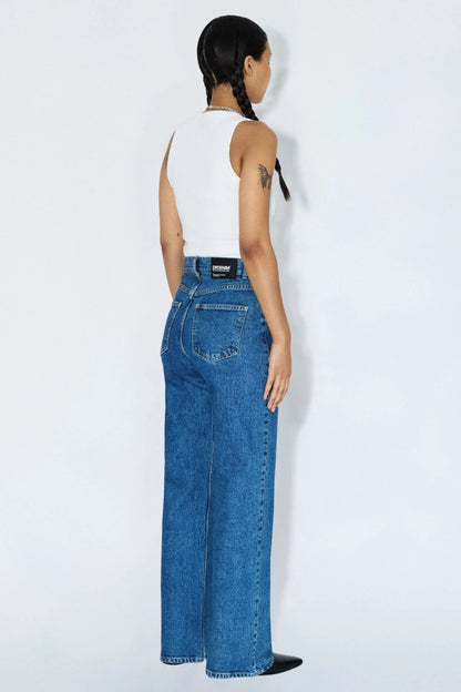 Vue trois-quarts dos du jeans Echo bleu denim rétro avec poches arrière, taille haute et coupe droite.