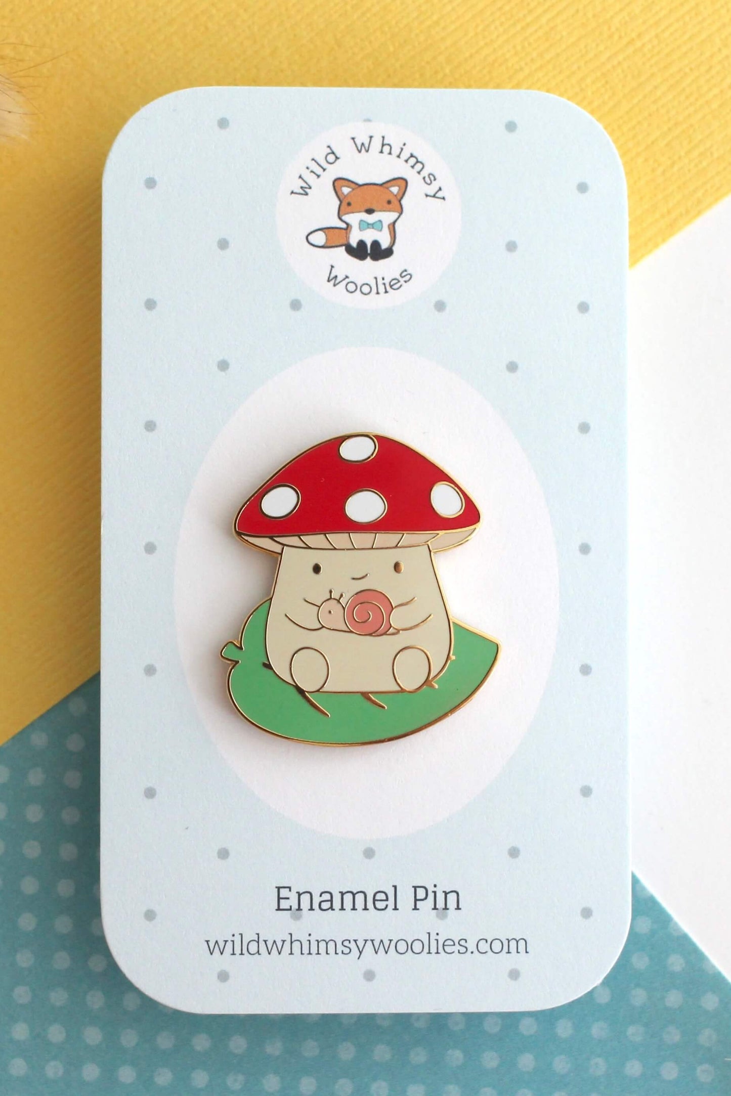 Épinglette champignon escargot présentée sur carte de support
