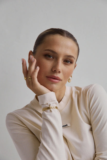 Bague dorée Gia portée avec look minimaliste – Accessoire chic