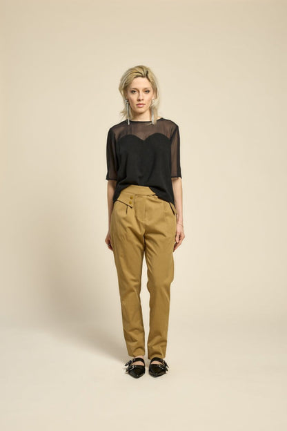 Haut L’Amour noir porté avec pantalon beige pour un style moderne et décontracté