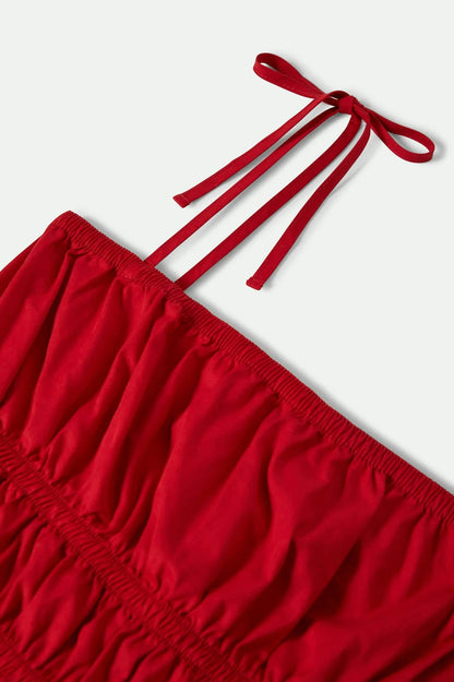 Gros plan sur les bretelles réglables du haut smocké rouge en coton