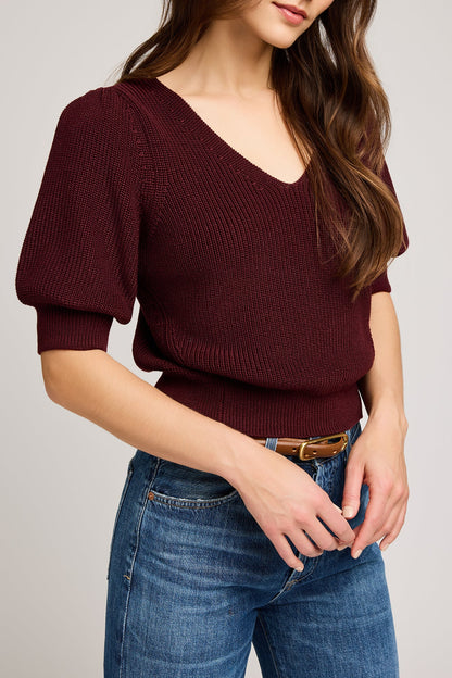 Vue de profil du haut merlot soulignant le volume des manches et la texture du tissu

