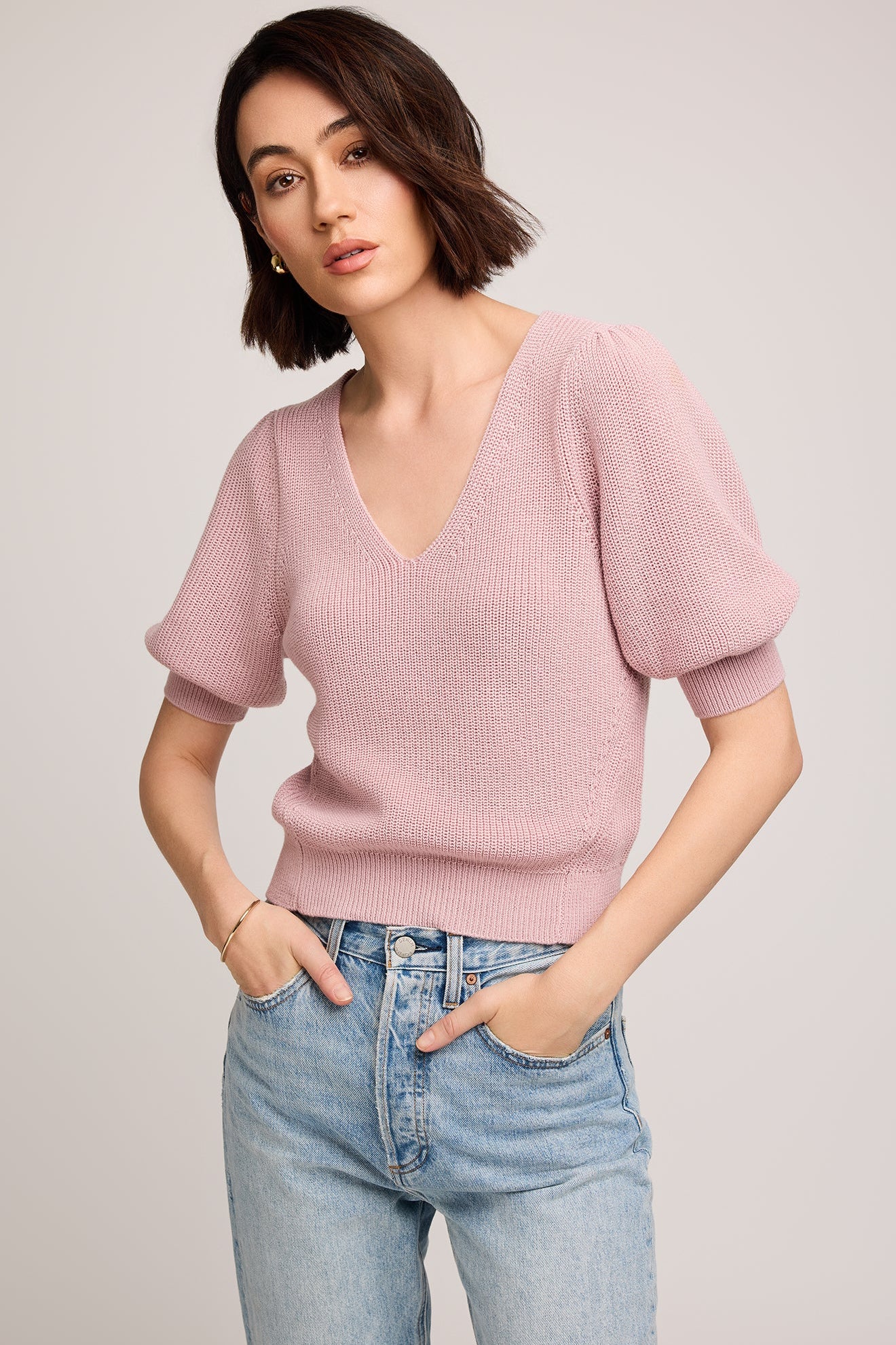 Vue de face du haut en tricot rose poudré avec décolleté en V et manches bouffantes