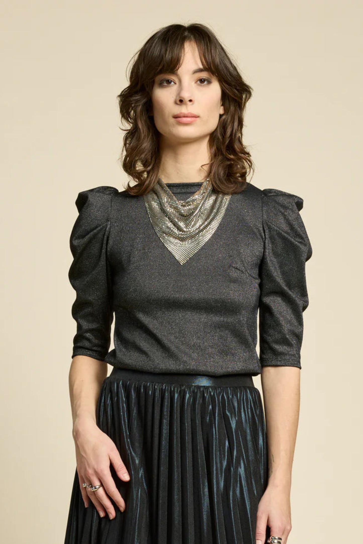 Détail du tissu brillant noir et manches structurées