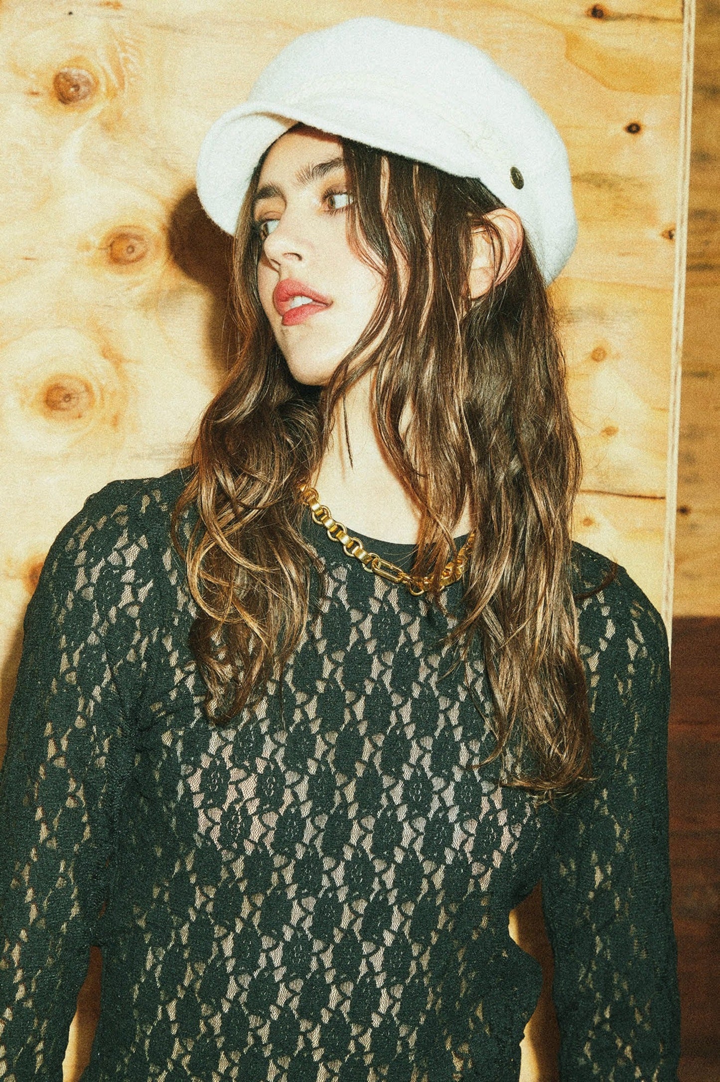 Haut Mathilda en dentelle noire porté avec chaîne dorée et chapeau blanc