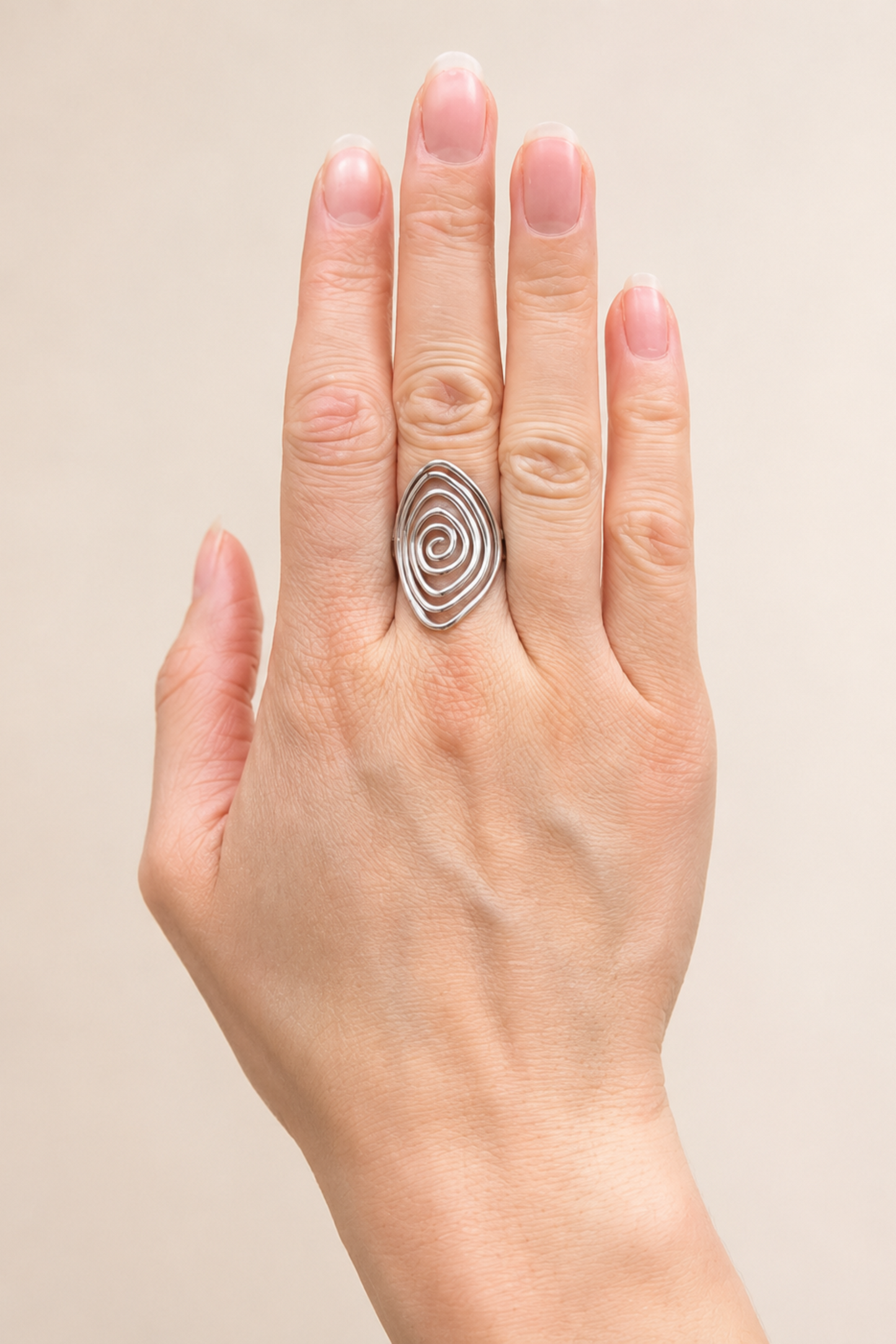 Bague Lilia argent portée sur la main, avec design spirale graphique et ajustable.