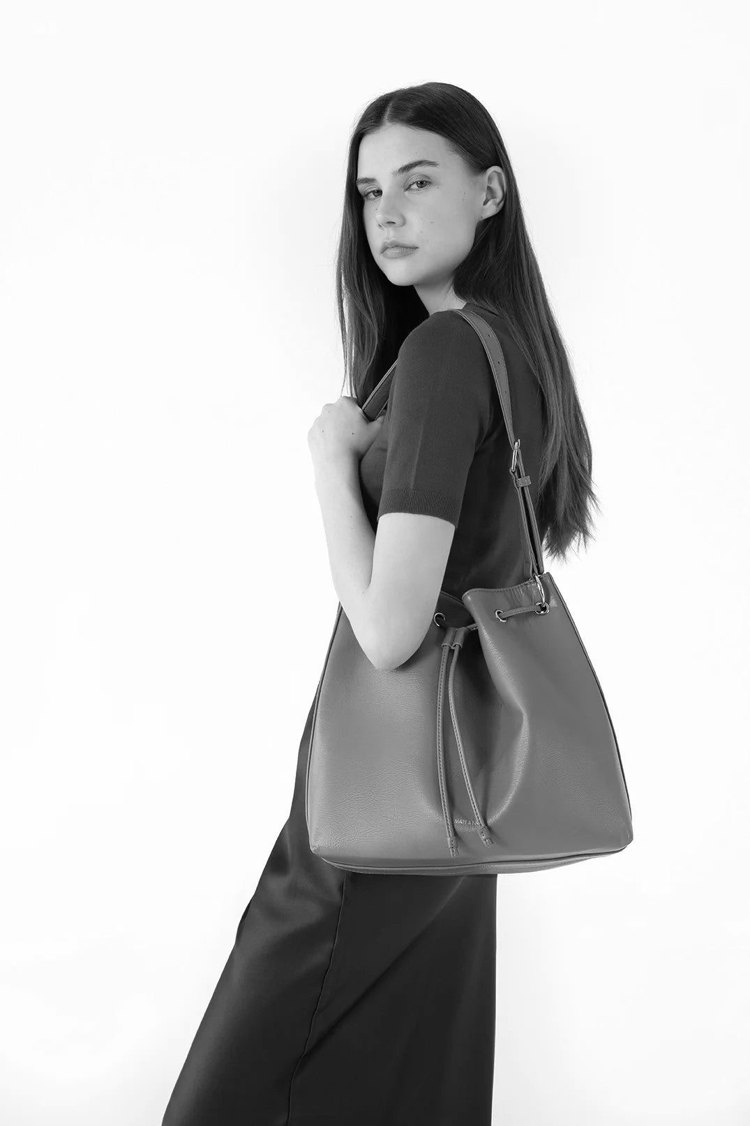 Sac Jan porté à l’épaule par un modèle de face. Silhouette élégante et taille du sac bien visible.