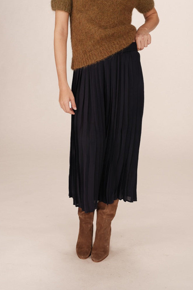 Jupe plissée marine vue de profil, coupe fluide