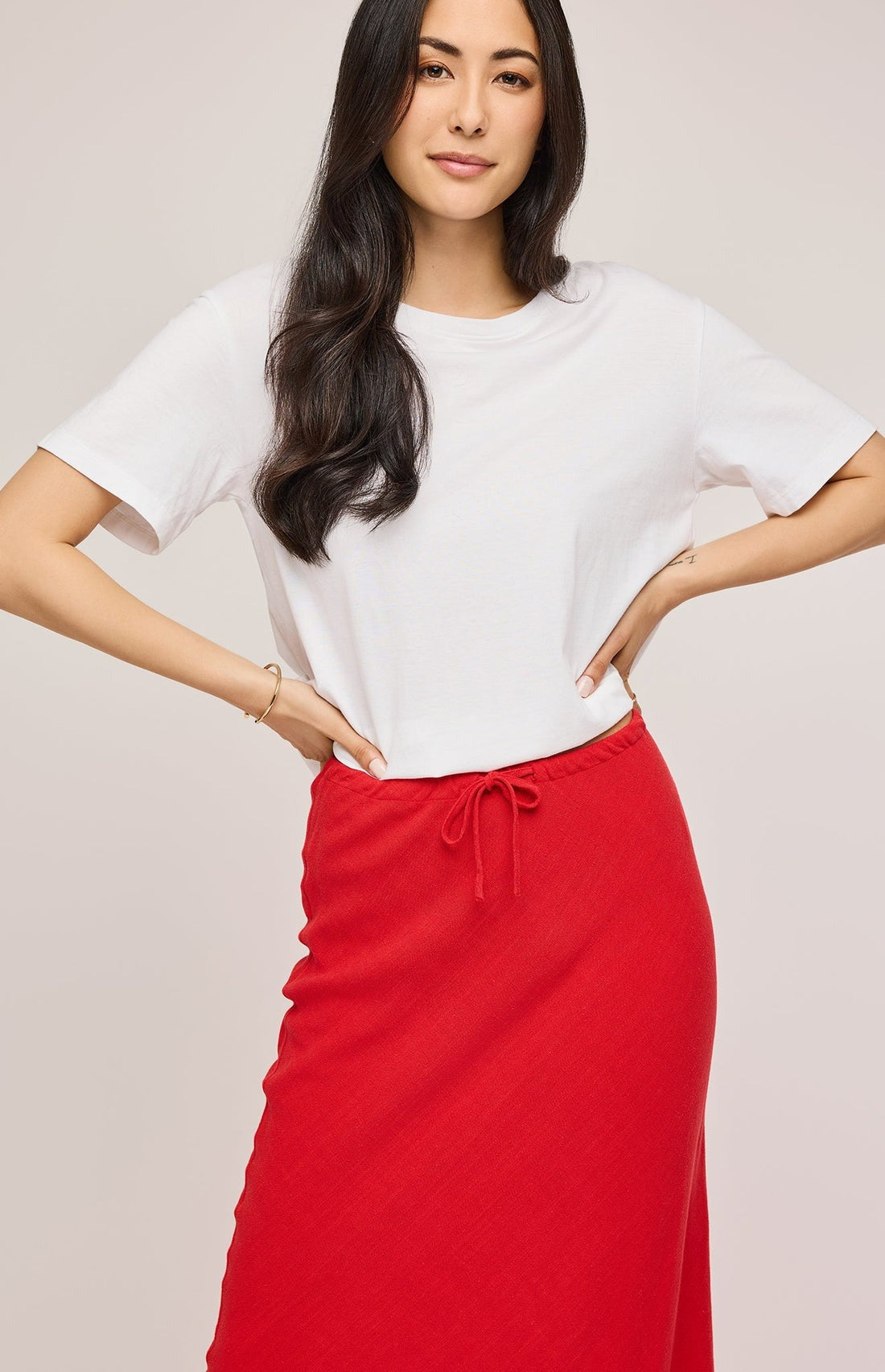 Gros plan sur la taille de la jupe rouge en tricot – cordon ajustable et texture douce.
