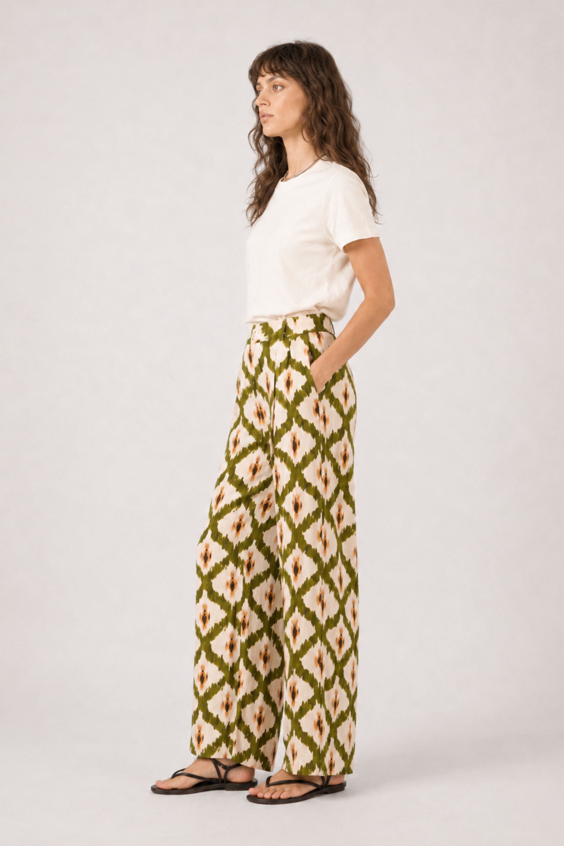 Pantalon Lillo vert porté de profil avec coupe large, imprimé graphique et poches latérales.