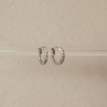 Créoles en argent accrochées à une tige – détail des pierres colorées

