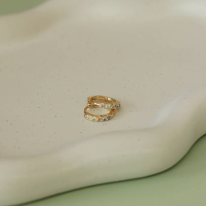 Créoles Lorato dorées posées sur plateau crème – Détail élégant en zircons