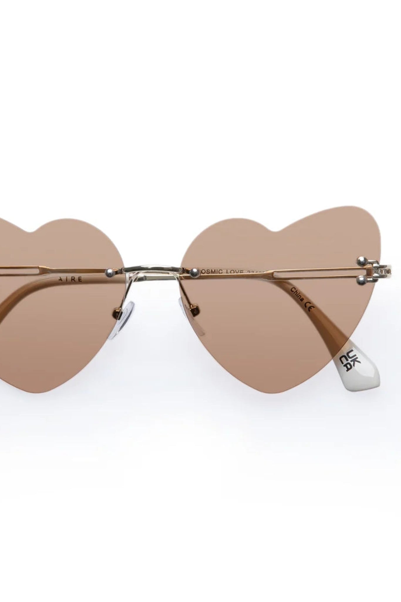 Vue de face des lunettes de soleil Lucie Marbre Or avec verres beige en forme de cœur et monture dorée.