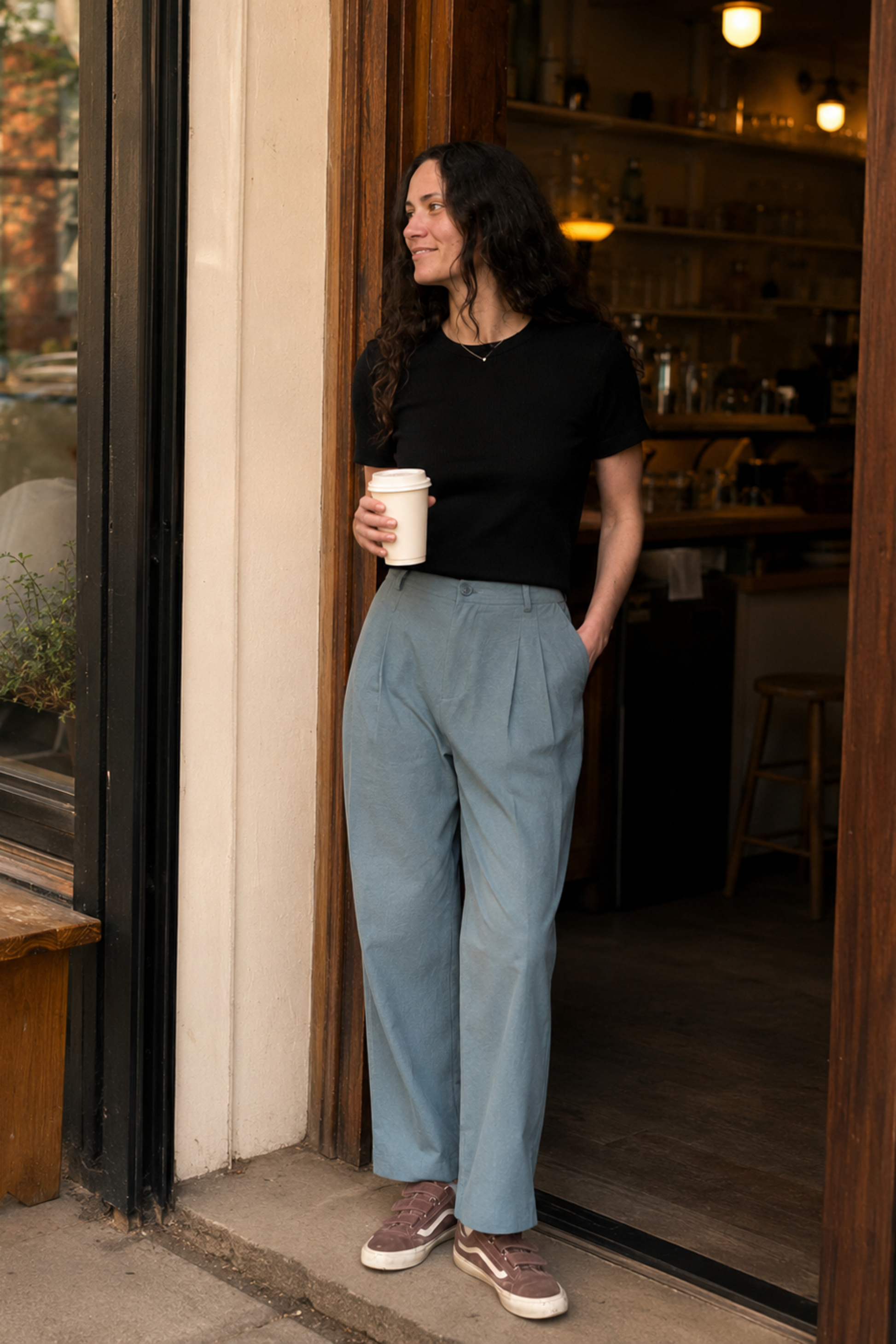 Pantalon droit bleu Marion porté devant un café avec plis à l’avant et coupe chic décontractée.