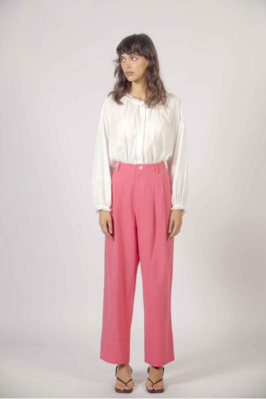 Pantalon droit rose taille haute porté avec blouse blanche fluide