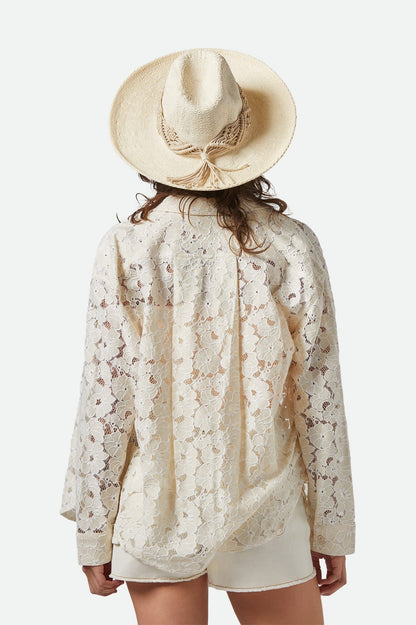 Chapeau de paille beige vu de dos avec franges en macramé – porté sur chemise dentelle