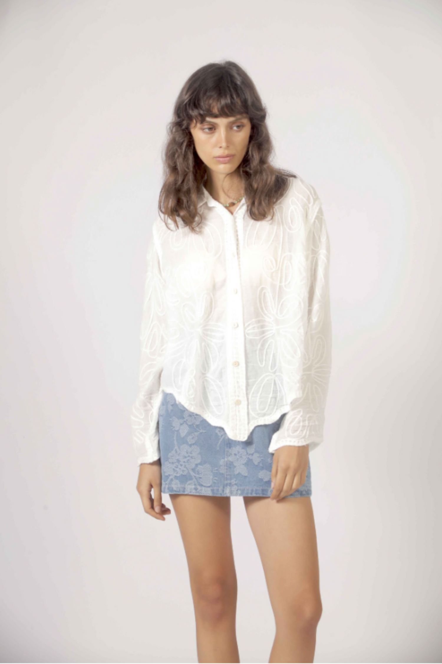 Détail des broderies florales ton sur ton de la chemise blanche