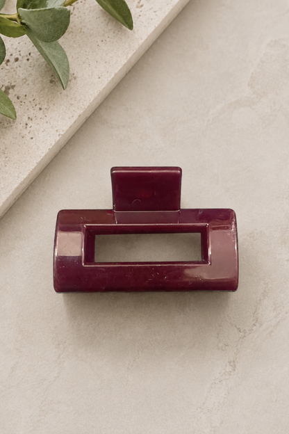 Mini pince rectangle bourgogne sur fond neutre avec ouverture centrale et fini brillant.