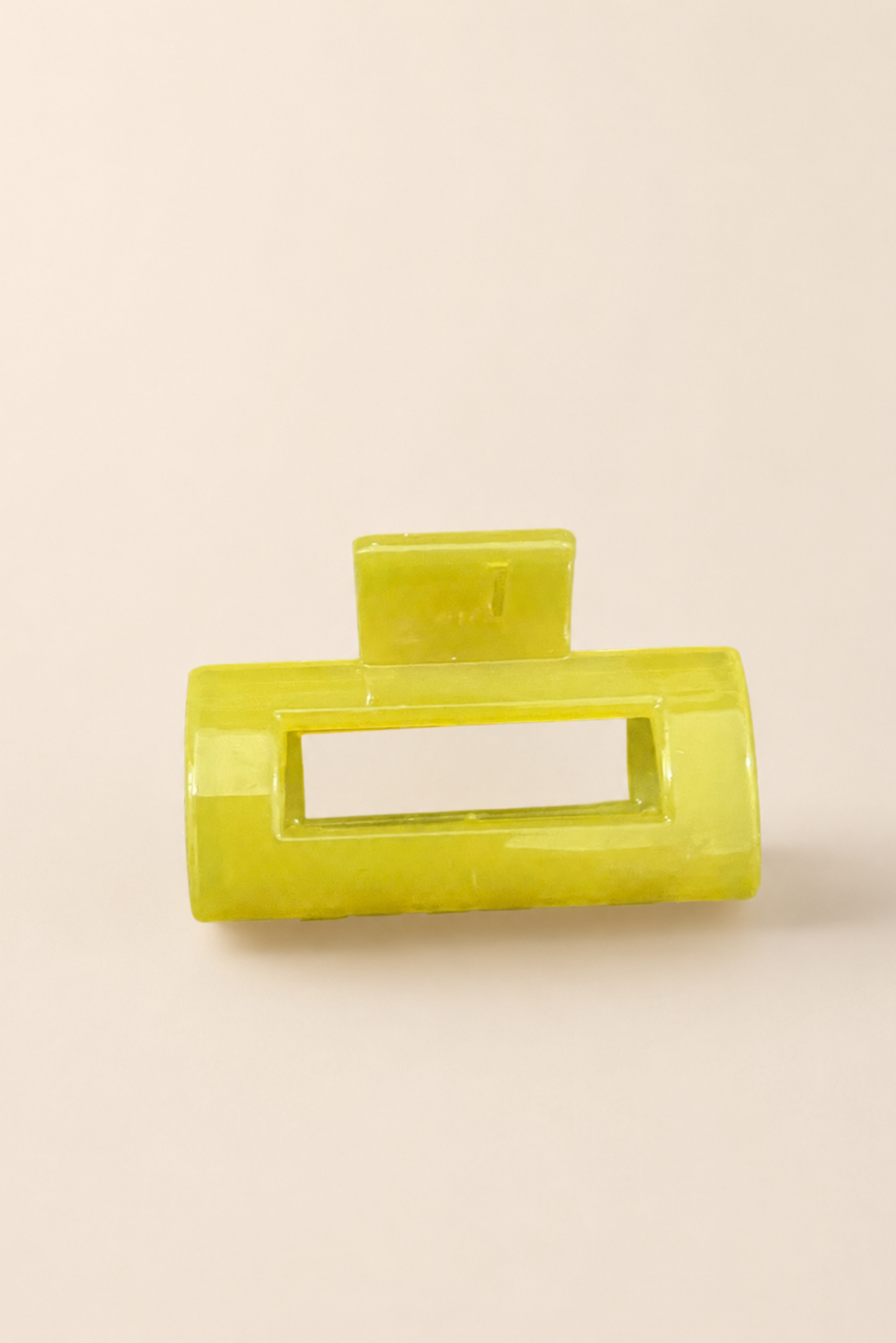 Mini pince rectangle jaune au fini brillant, parfaite pour ajouter une touche colorée à une coiffure.