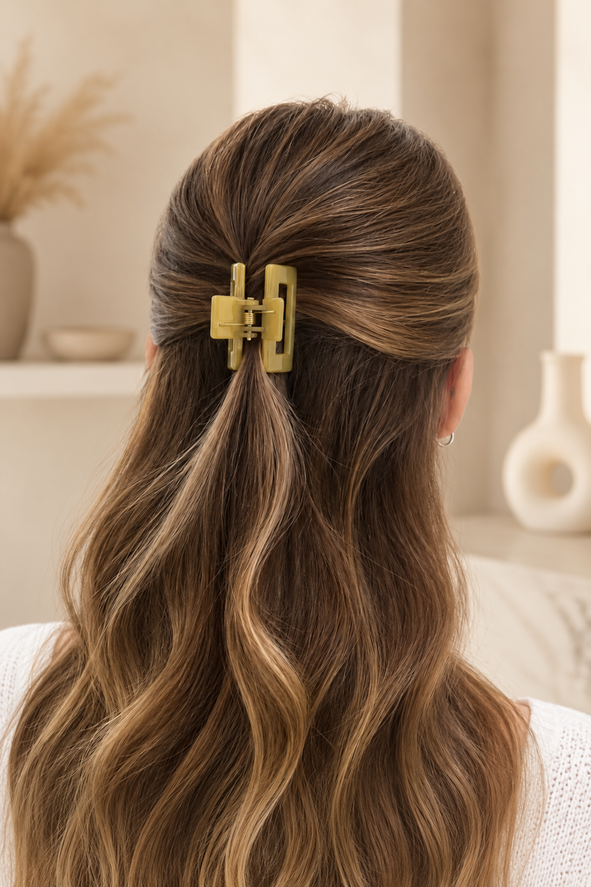 Mini pince rectangle portée dans les cheveux en demi-attache avec finition brillante et style chic.