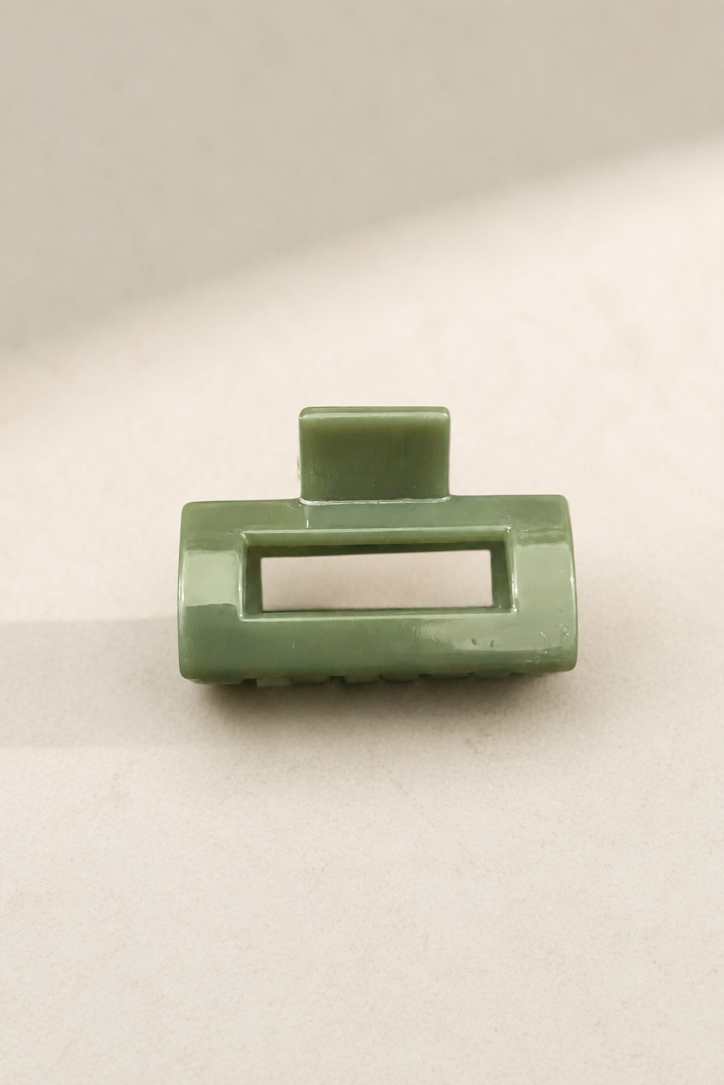 Mini pince rectangle sauge avec fini brillant, parfaite pour une attache discrète et élégante.