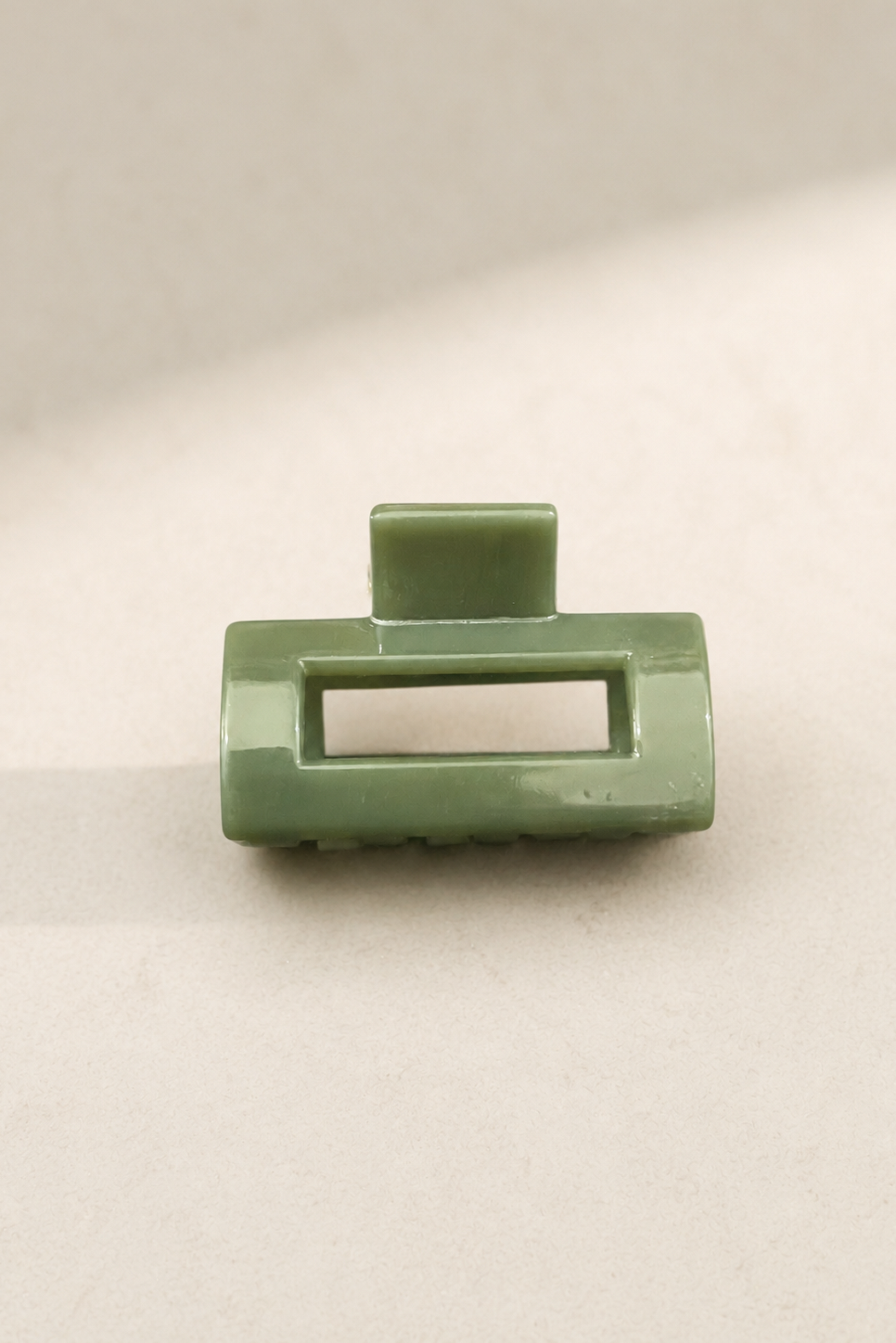 Mini pince rectangle sauge avec fini brillant, parfaite pour une attache discrète et élégante.