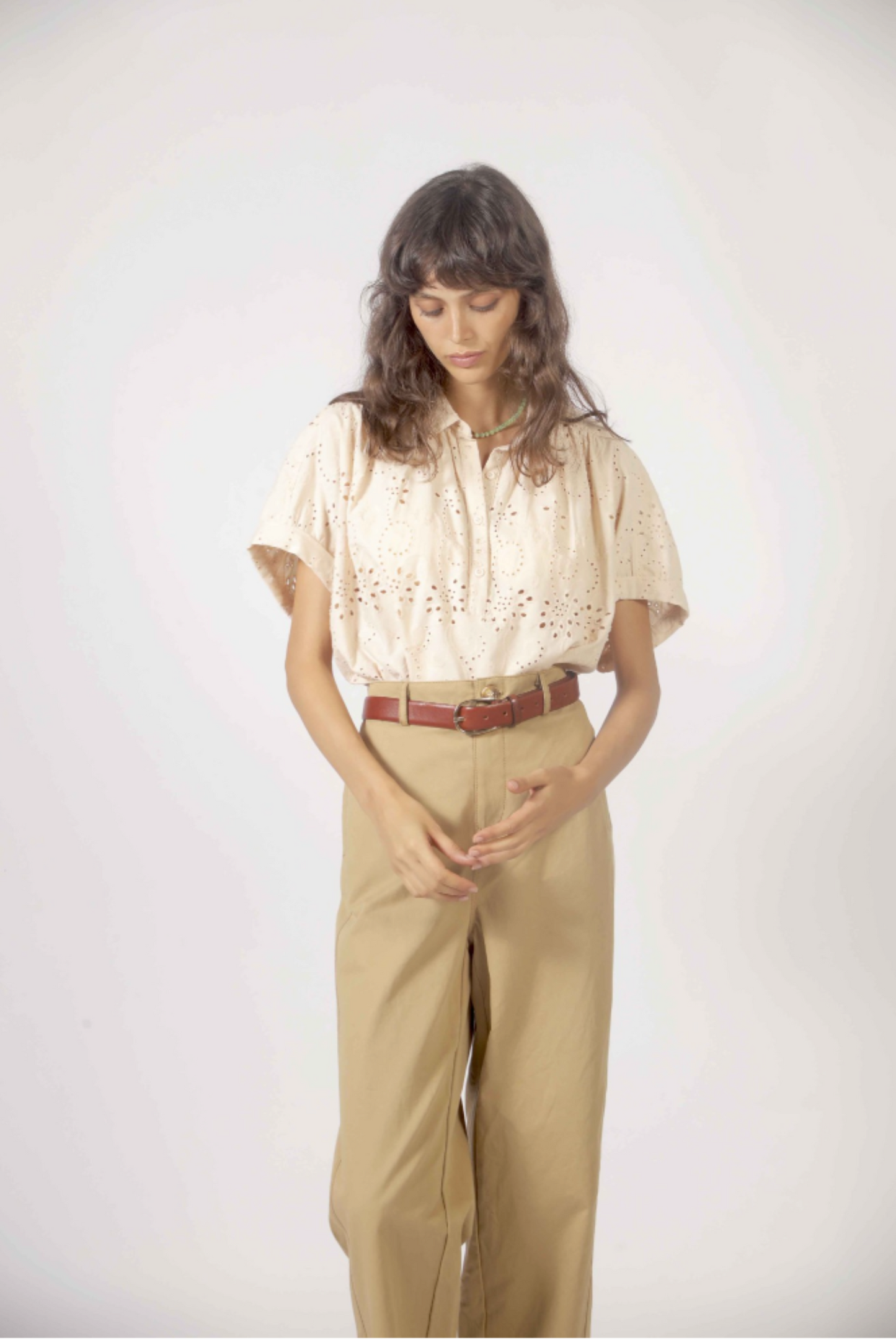 Détail du haut Molly beige avec broderie anglaise ajourée, col chemisier et manches fluides.
