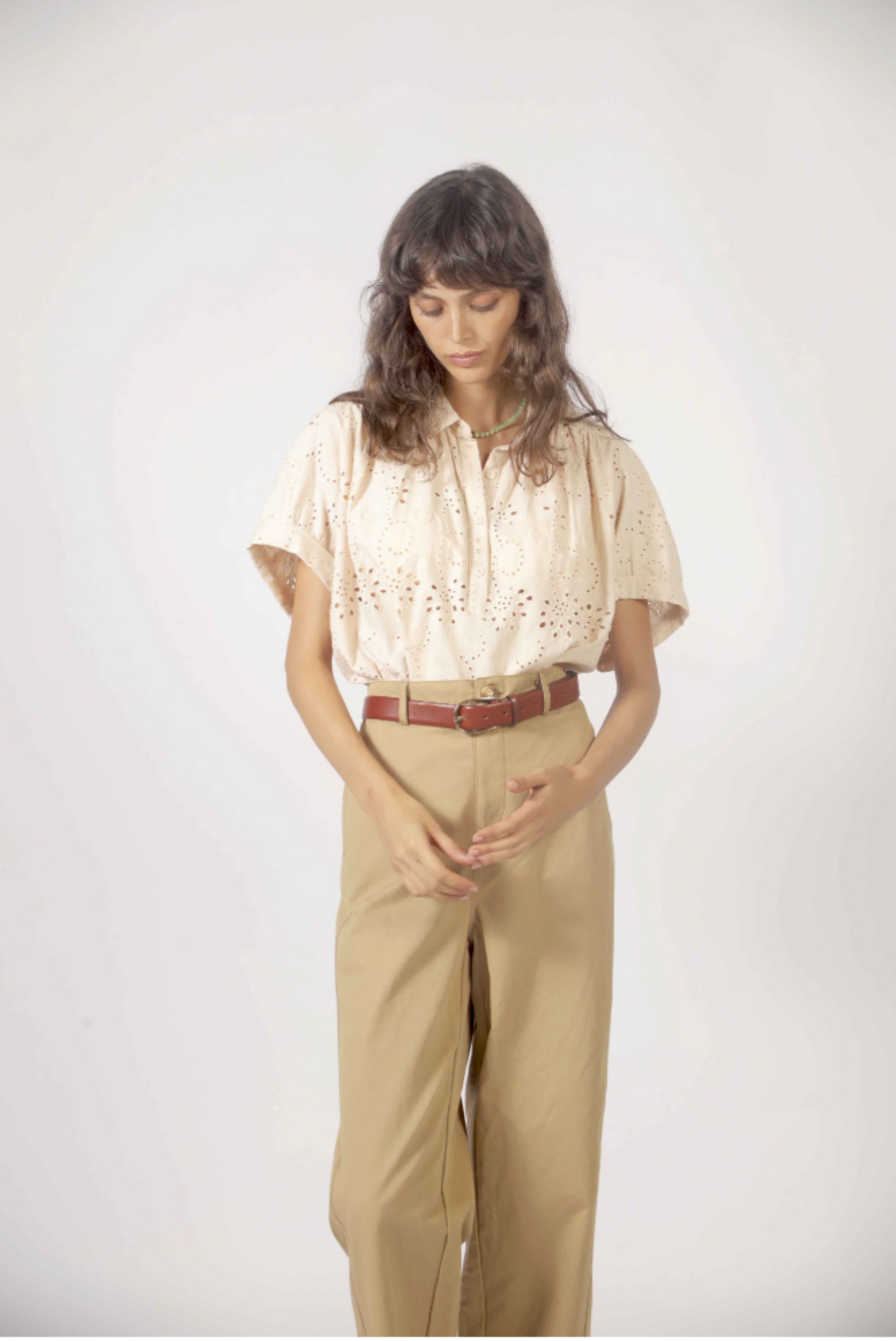 Détail du haut Molly beige avec broderie anglaise ajourée, col chemisier et manches fluides.