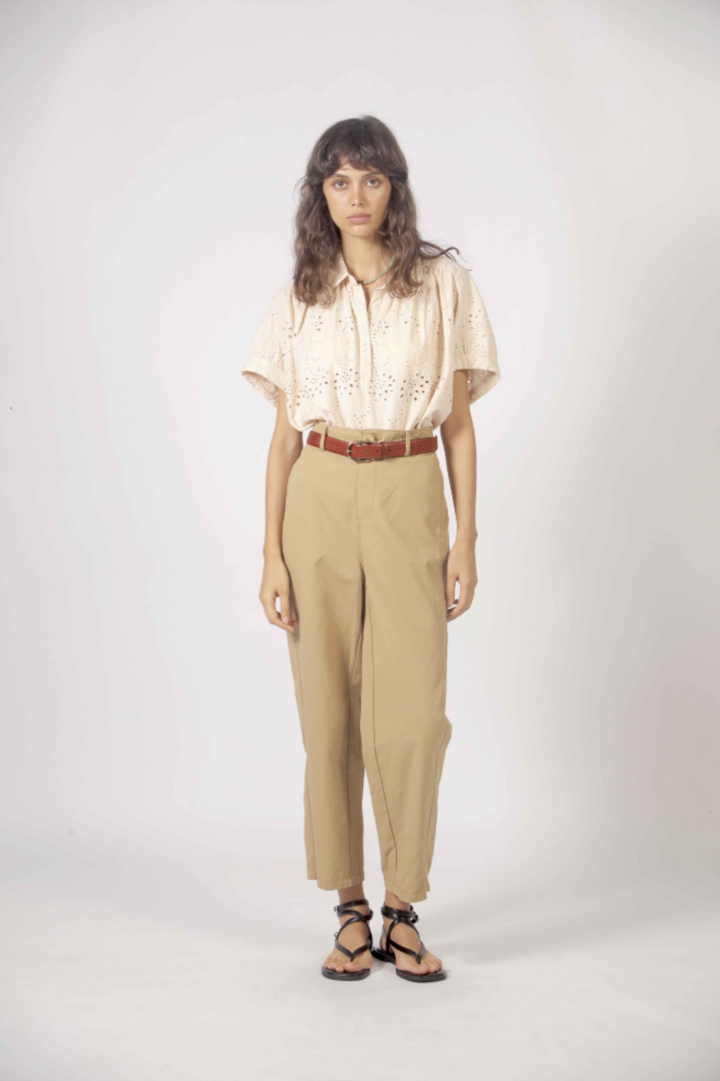 Haut Molly beige porté rentré dans un pantalon taille haute avec ceinture, pour un look bohème chic.