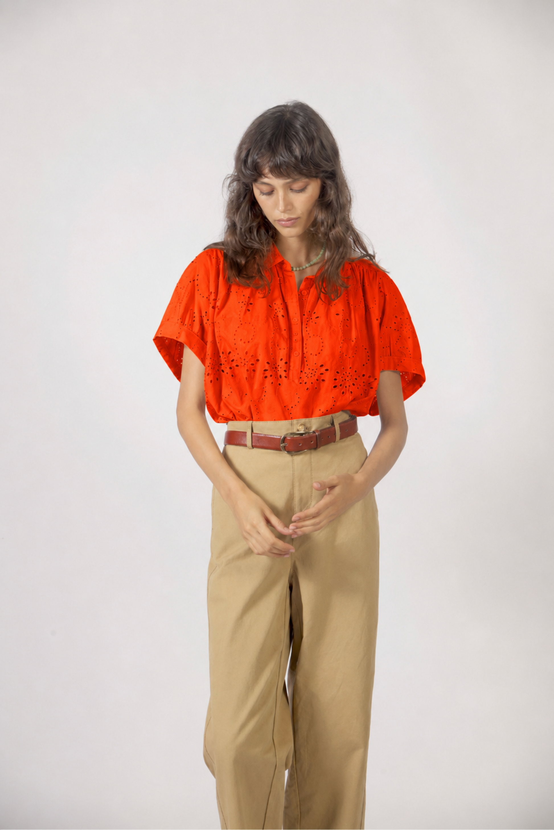 Détail du haut Molly orange avec broderie anglaise ajourée, col chemisier et coupe fluide en coton.