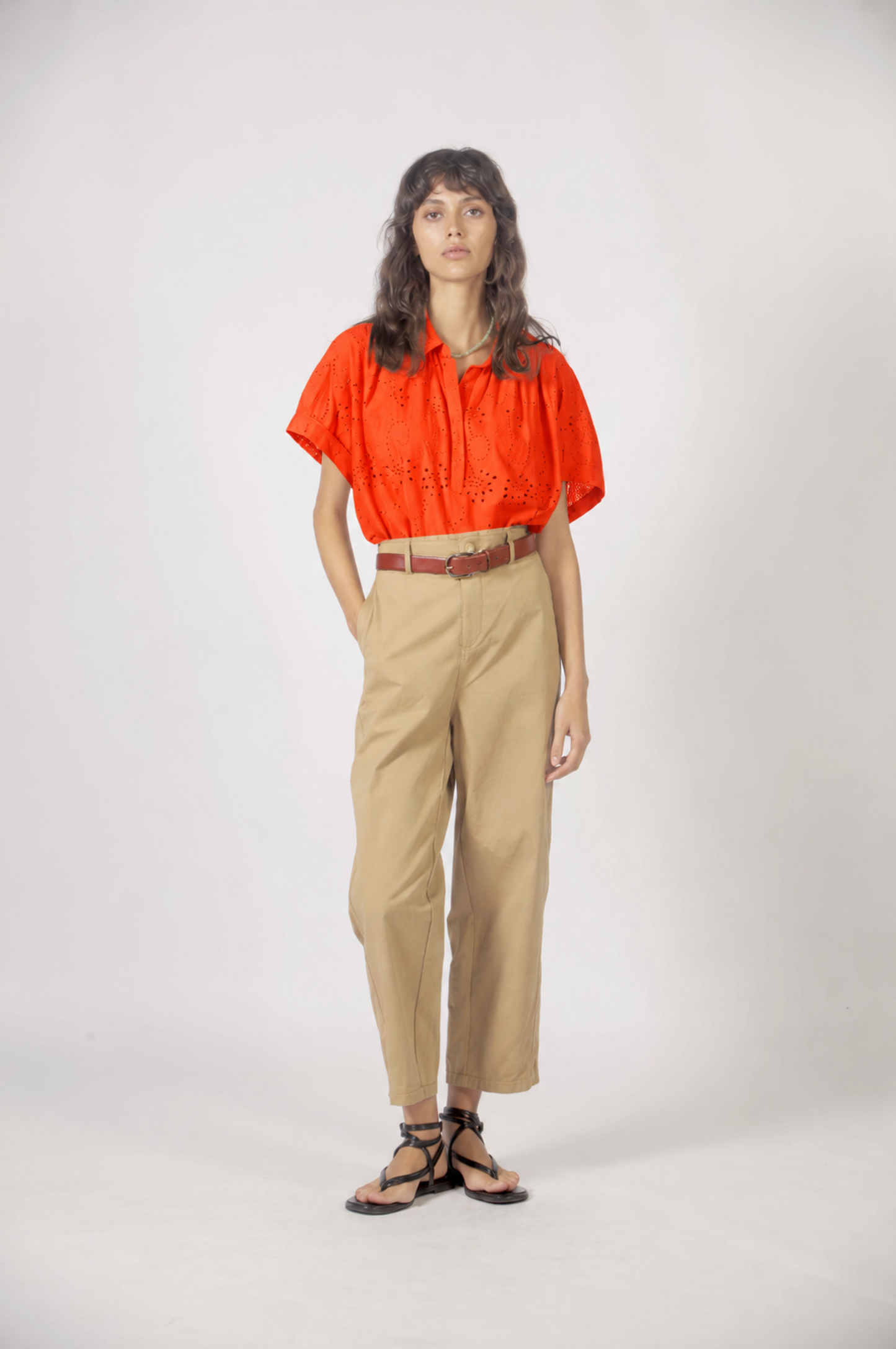 Haut Molly orange porté de face avec manches courtes amples, broderie anglaise et pantalon taille haute.