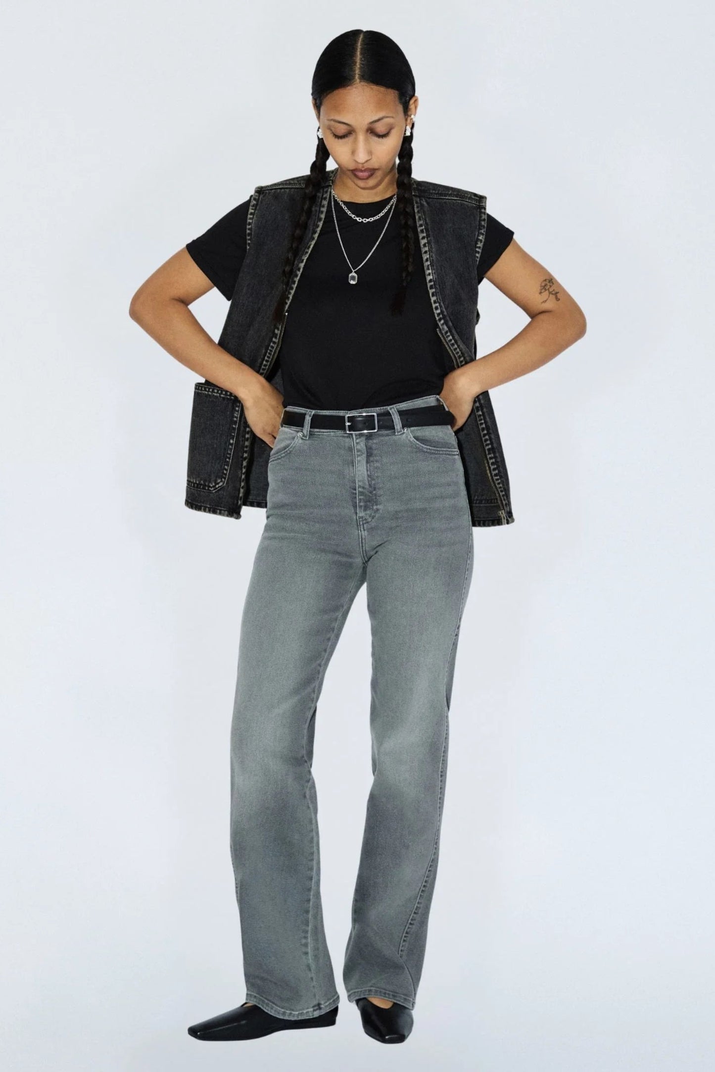 Jeans Moxy gris clair porté avec une ceinture noire, coupe taille haute, jambe droite et allure casual chic.