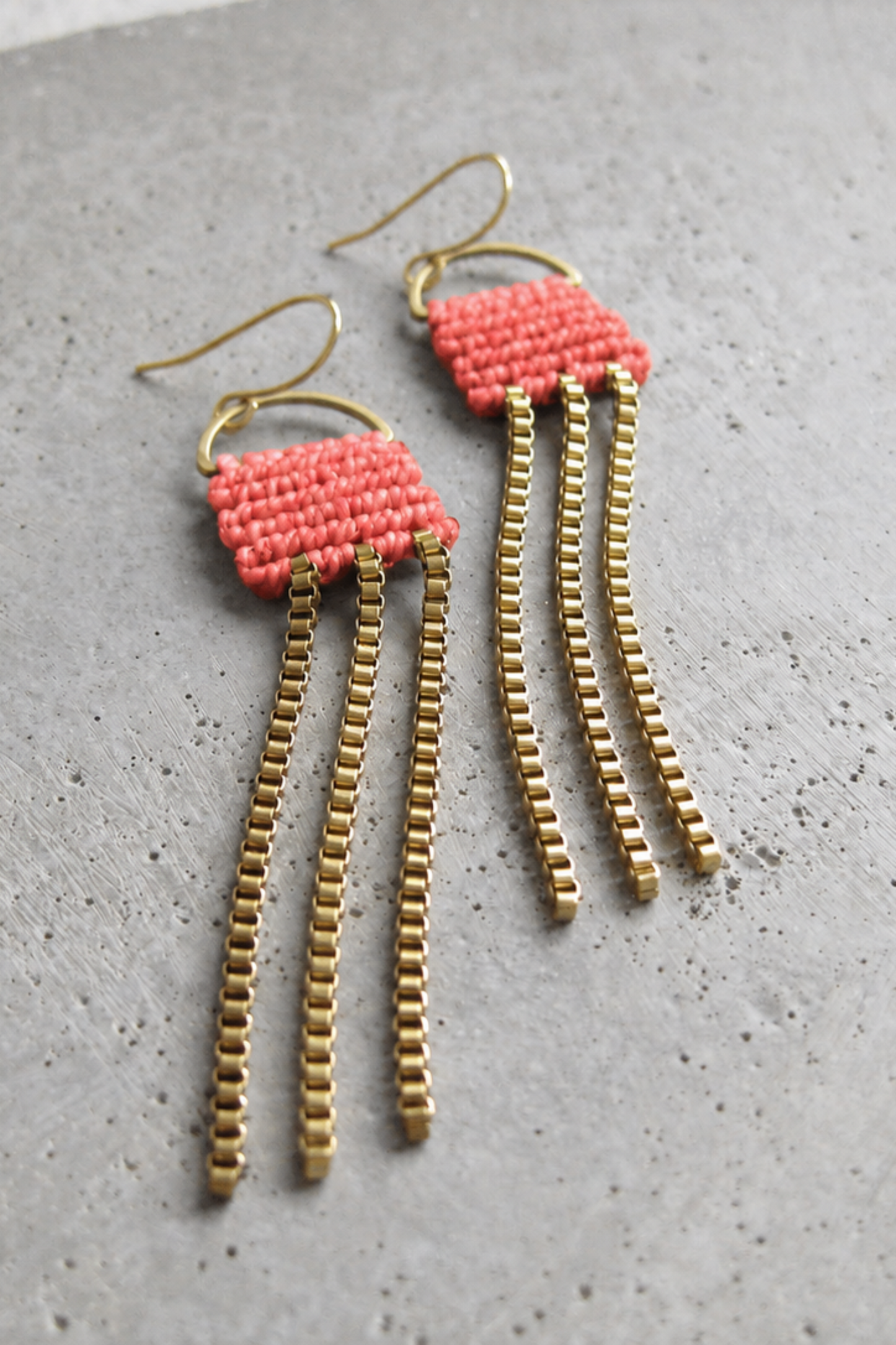 Boucles d’oreilles longues Naïad Corail avec détail en micro macramé corail et chaînes dorées.