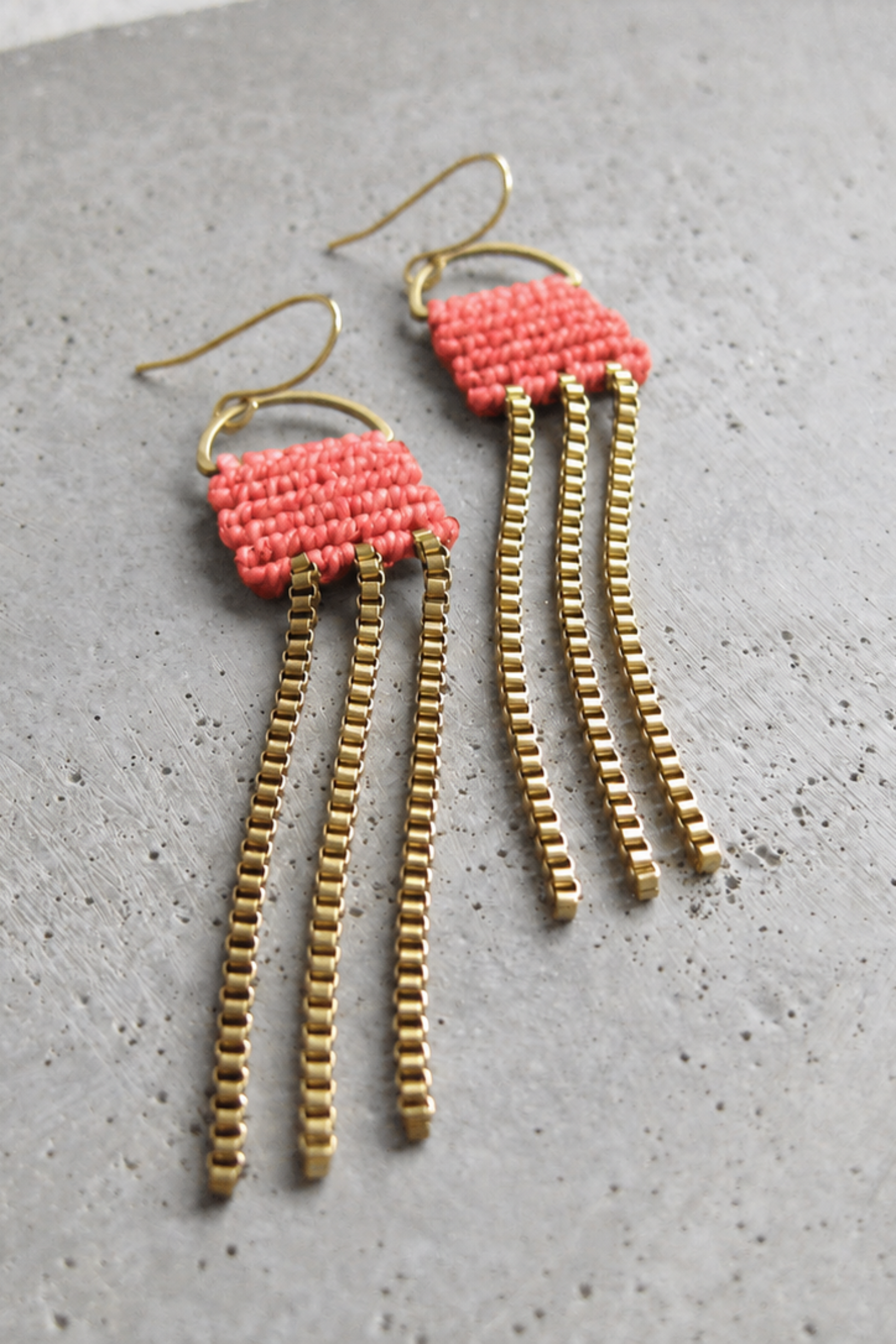 Boucles d’oreilles longues Naïad Corail avec détail en micro macramé corail et chaînes dorées.