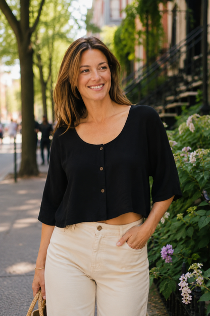 Blouse Nao Noir portée avec short assorti, devant boutonné et coupe courte estivale.