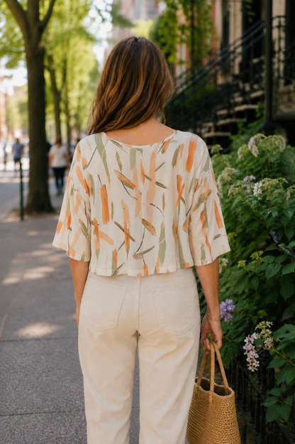 Blouse Nao Orange vue de dos avec imprimé abstrait coloré, coupe courte fluide et manches larges.