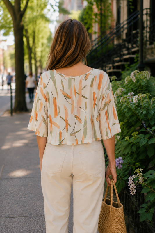 Blouse Nao Orange vue de dos avec imprimé abstrait coloré, coupe courte fluide et manches larges.