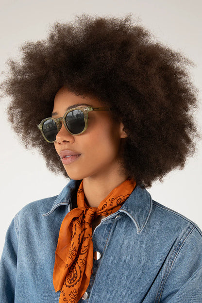 Lunettes de soleil Nika olive portées par une femme avec veste en denim et foulard orange - vue de côté